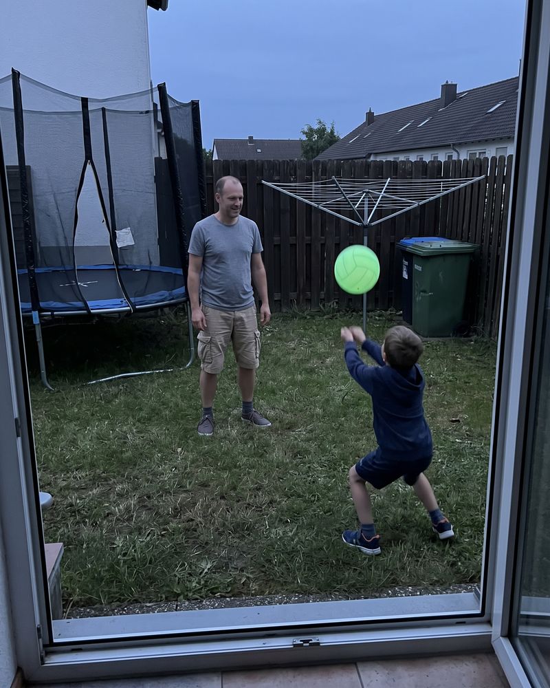 Kundenfoto: Vater und Sohn spielen in der Dämmerung im Garten