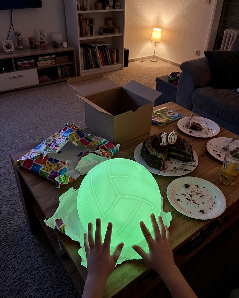 Kundenfoto: leuchtender Volleyball zwischen Geschenkpapier und Geburtstagskuchen